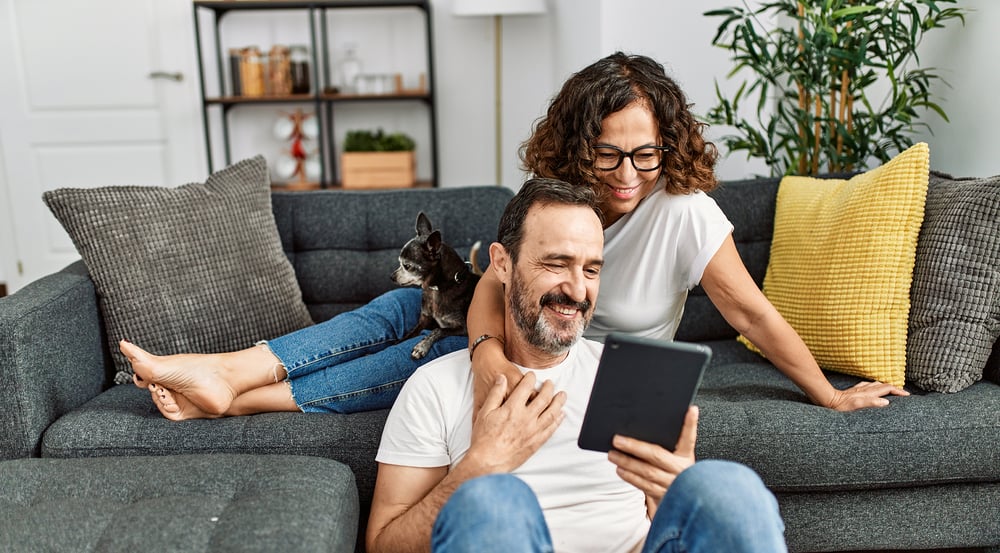 hispanic couple smiling happy and using touchpad