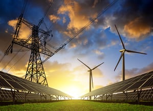 Solar panels with wind turbines and electricity pylon at sunset. Clean energy concept. AdobeStock_96622127